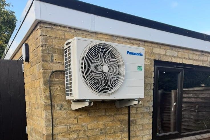 Outdoor condenser unit installed on a residential wall