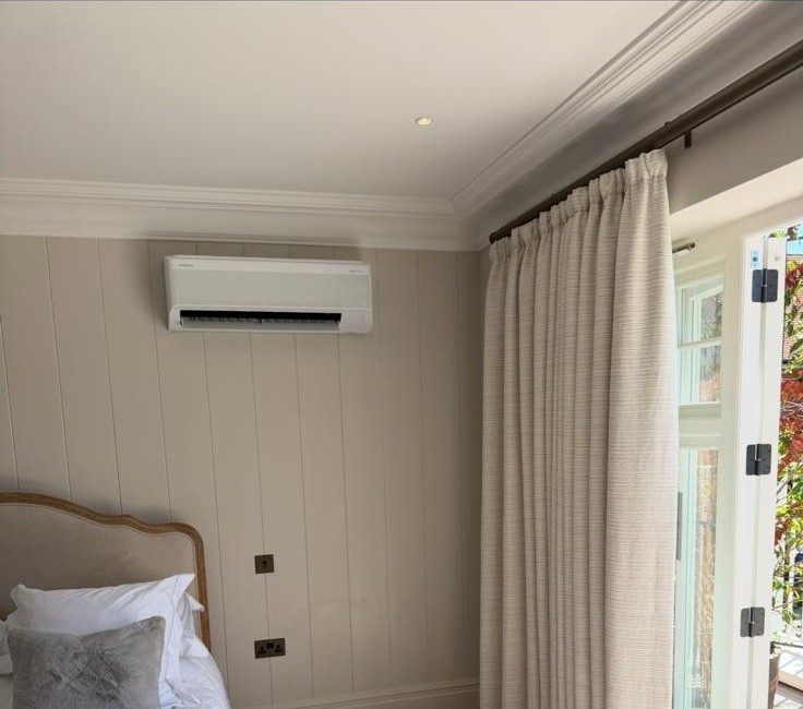 Wall-mounted AC unit installed in a bright bedroom