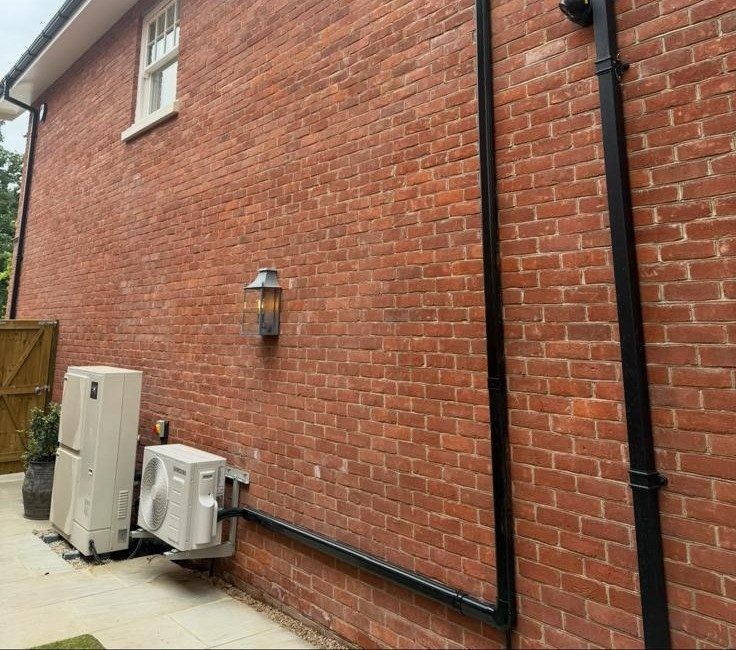 Outdoor condenser units installed on a red brick house